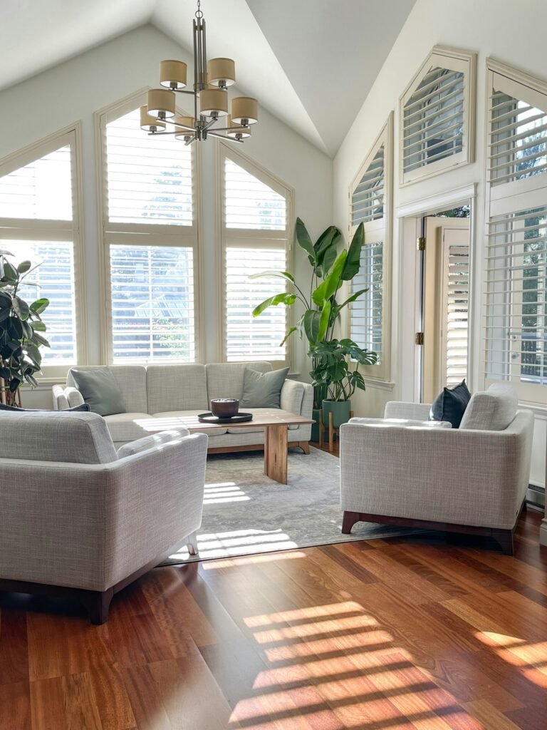 Bright living room with vaulted ceiling, chandelier and sunlit windows