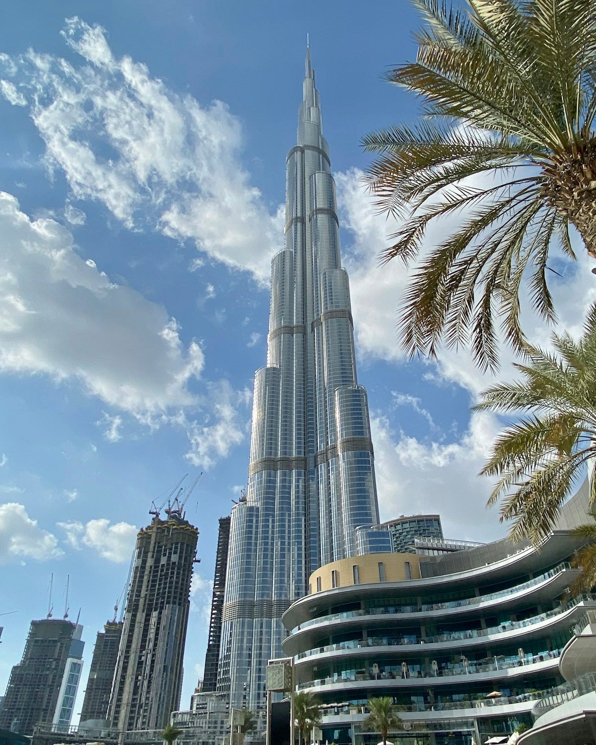 Burj Khalifa against a bright blue sky framed by palm trees – Dubai property for UK investors